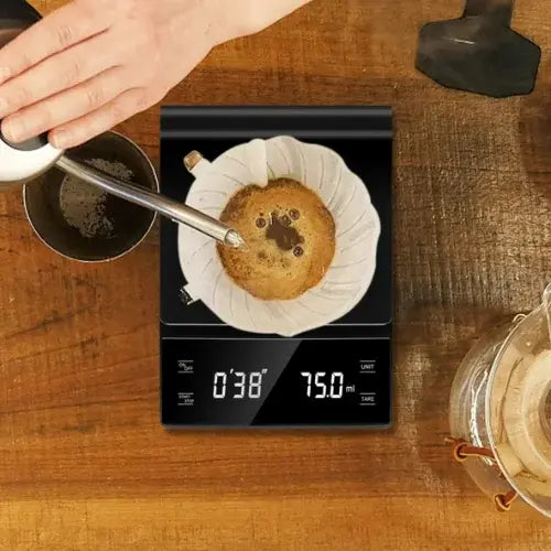 Du café est versé dans une tasse sur une balance digitale qui pèse en direct