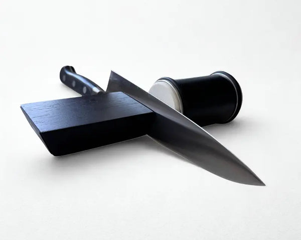 Aiguiseur de couteau roulant noir et couteau japonais sur fond blanc