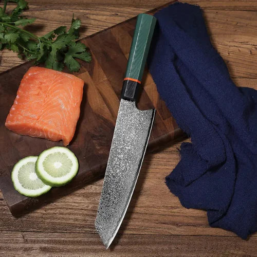 Couteau en acier damas et manche tricolore sur une planche en bois à côté d'un morceau de poisson
