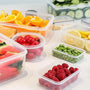 Boites en plastiques remplies de fruits, sur fond blanc