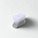 Tête e brosse disposée sur fond blanc.