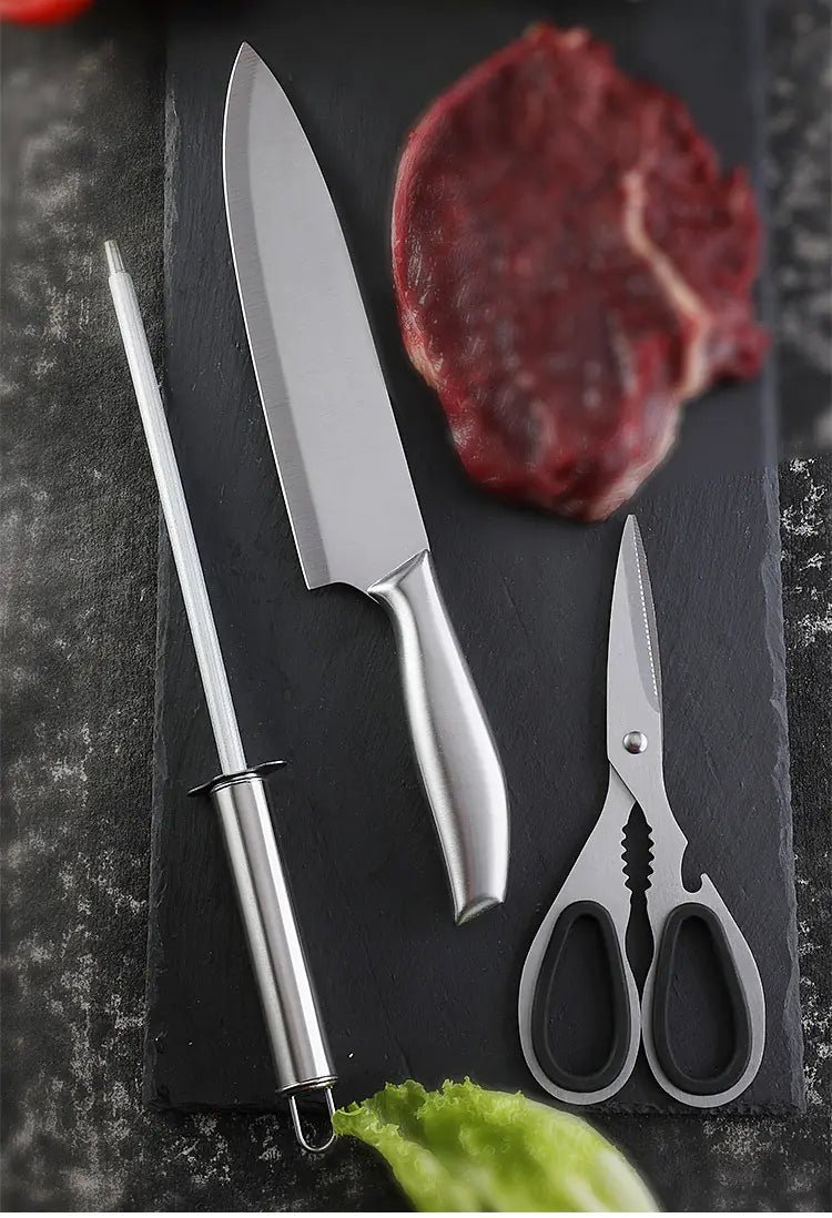 Couteau en Inox, fusil et ciseaux sur fond gris