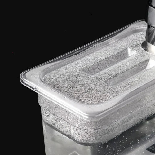 Conteneur plastique de cuisson sous vide en action, sur fond noir