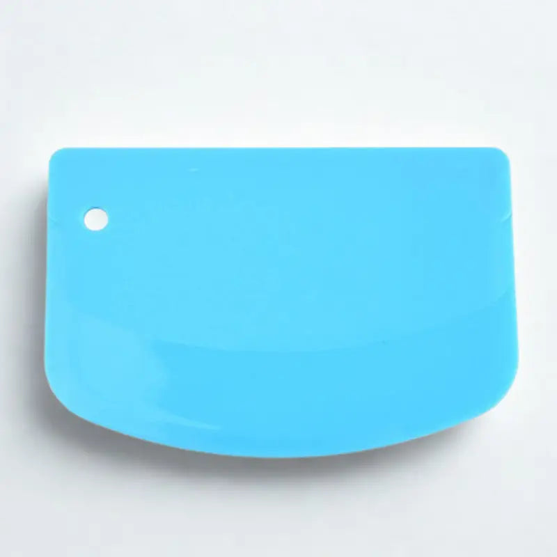 Coupe-pâte en silicone bleu sur fond blanc