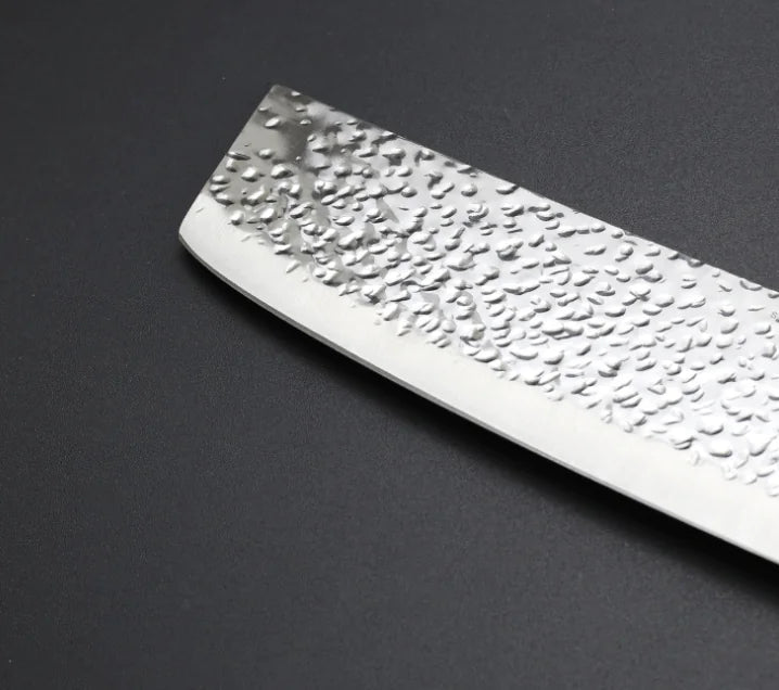 Vue de la lame d'un couteau nakiri sur fond gris