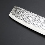 Vue de la lame d'un couteau nakiri sur fond gris