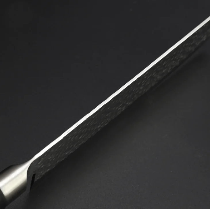 Vue du dos de la lame d'un couteau nakiri sur fond gris
