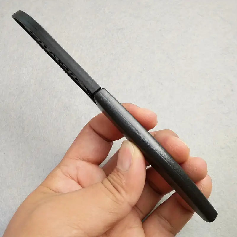 Couteau céramique noir et étui tenu par une main sur fond blanc