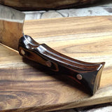 Couteau nordique manche en bois sur pierre et planche en bois