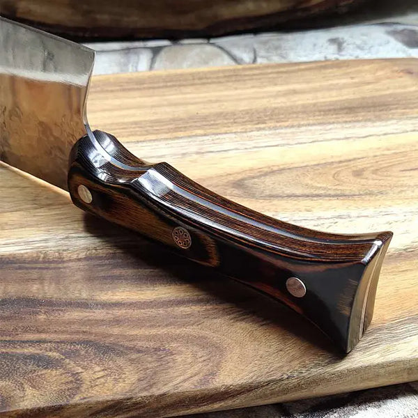 Couteau nordique manche en bois sur pierre et planche en bois