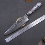 Couteau de chef en acier damas manche rouge et blanc et outil de mesure sur fond gris
