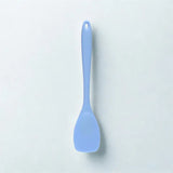 Cuillère bleue sur fond blanc
