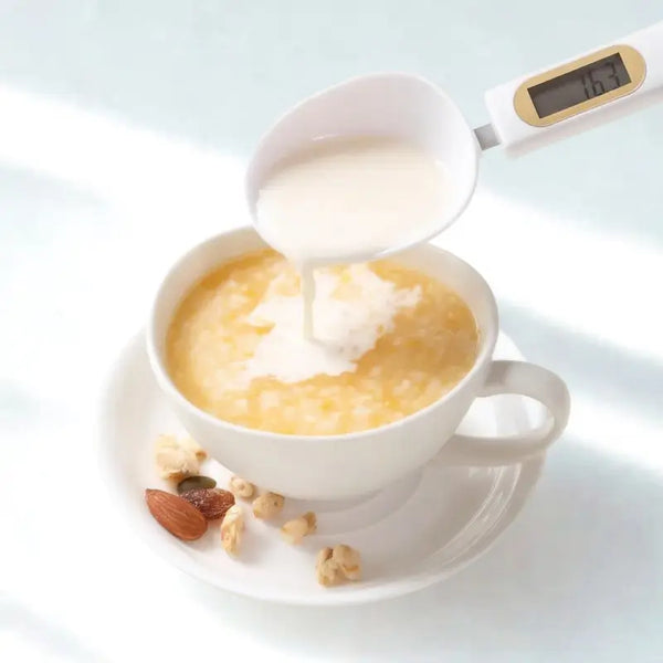 Cuillère verse lait dans tasse de café