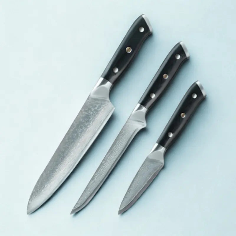 3 couteaux en acier damas sur fond blanc