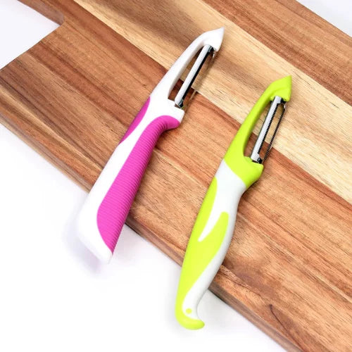 Éplucheur rose et blanc et éplucheur vert et blanc sûr planche en bois