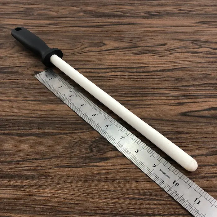 Fusil à aiguiser en céramique blanche et règle sur bois