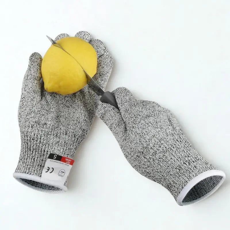 Gants de protection professionnels et citron en train d'être coupé sur fond blanc