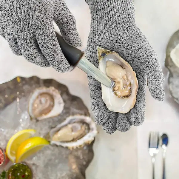 Huître ouverte et couteau sur gant anti-coupure