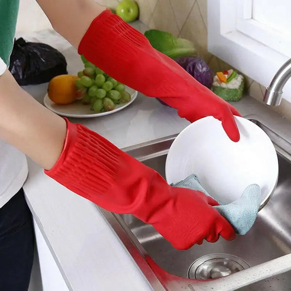 Une personne nettoie une assiette avec des gants rouges