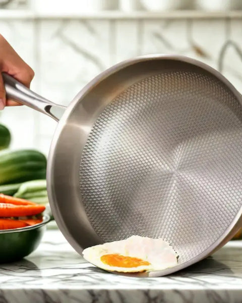 Poêle inox sur fond blanc avec légumes