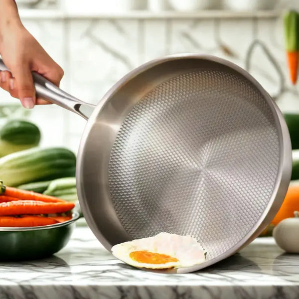Poêle inox sur fond blanc avec légumes