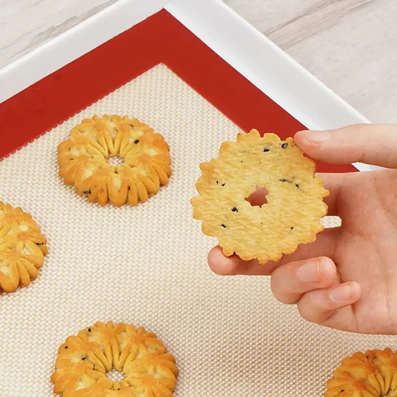 Pâtisserie tenue par main et tapis cuisson en dessous