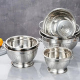 De nombreuses passoires en inox sur fond gris