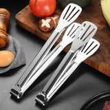 Pinces barbecue inox sur planche en bois