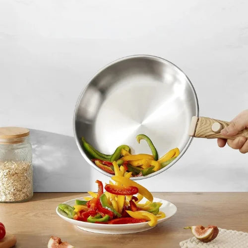 Poêles en inox à poignée amovible en bois versant des légumes