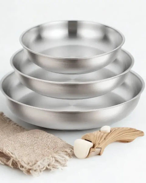 3 poêles en inox et poignée amovible bois sur fond blanc