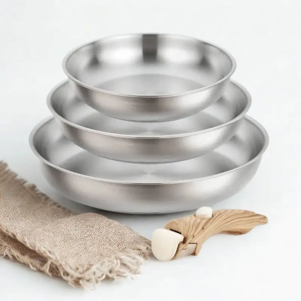 3 poêles en inox et poignée amovible bois sur fond blanc