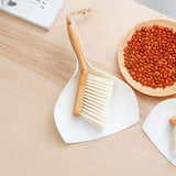 Brosse et pelle sur une table en bois