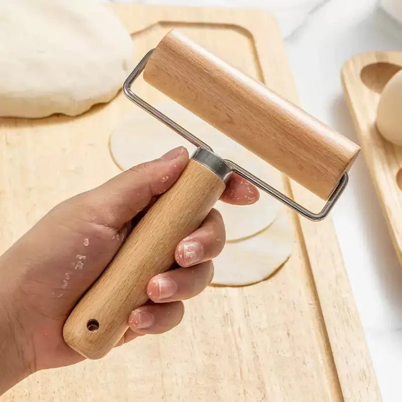 Rouleau en bois tenu par une main