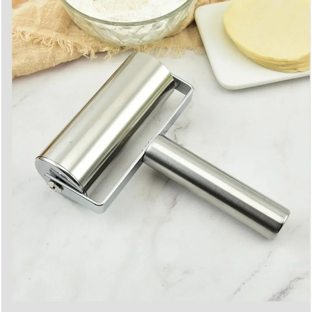 Rouleau à pâte en inox sur marbre blanc