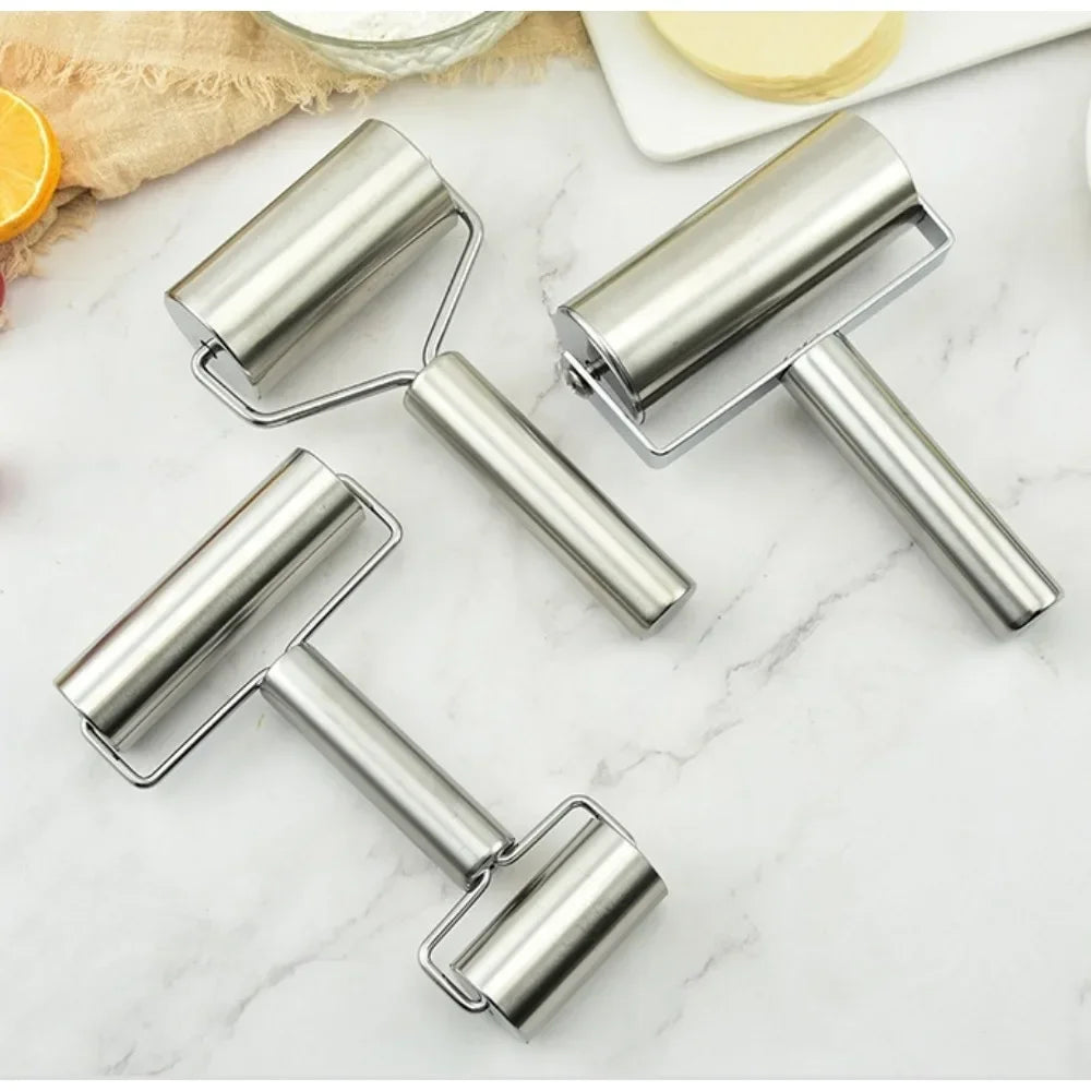 Rouleau à pâte en inox sur marbre blanc