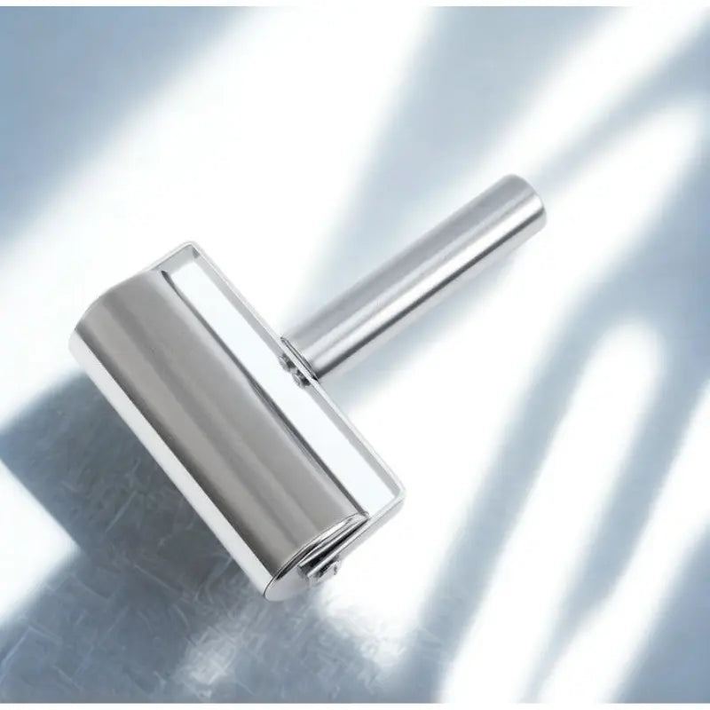 Rouleau à pâte en inox sur fond blanc