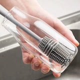 Brosse de nettoyage en plastique, en forme de tige, en action.