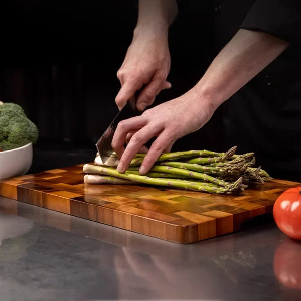 Planche à Découper en Bois avec des asperges en train d'être coupées dessus