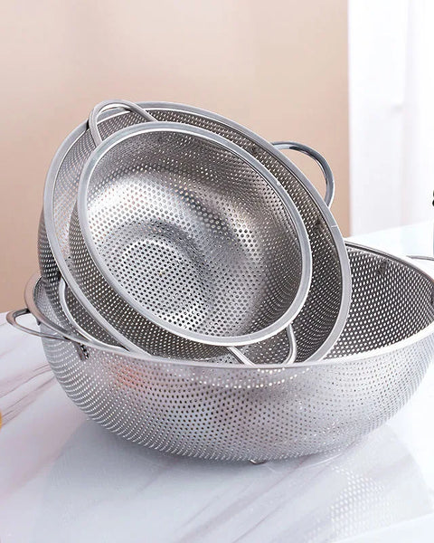 Trois passoires en inox sur un support en marbre blanc