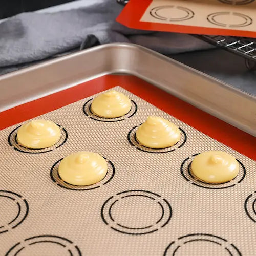 Macarons sur tapis et plaque