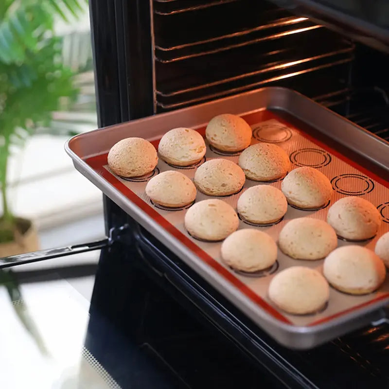 Macarons sur tapis et plaque dans four