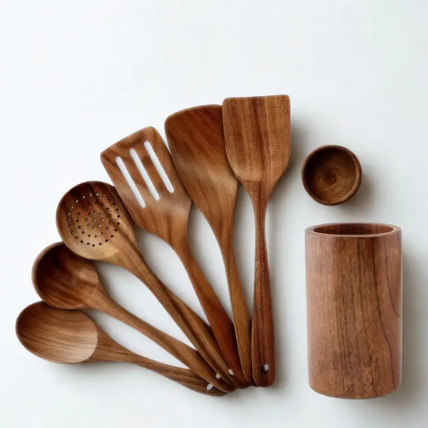 Spatules, louches et contenant en bois sur fond blanc