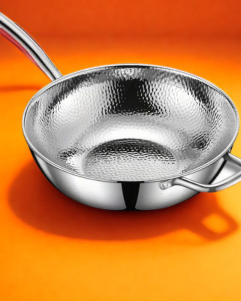 Wok en acier inoxydable sur fond orange