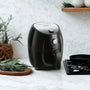 Air fryer et romarin sur fond blanc