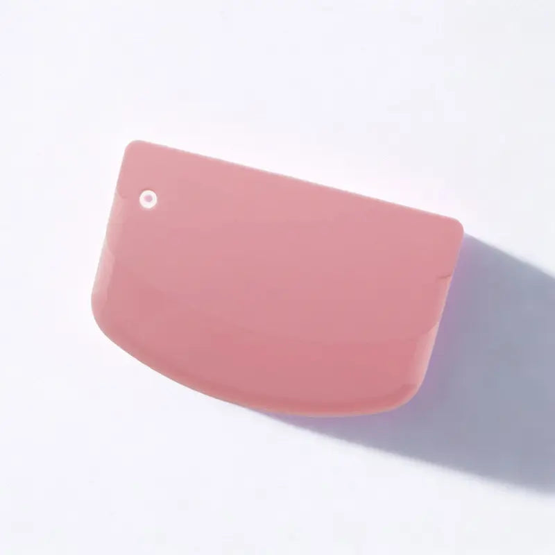 Coupe-pâtes en silicone rose sur fond blanc