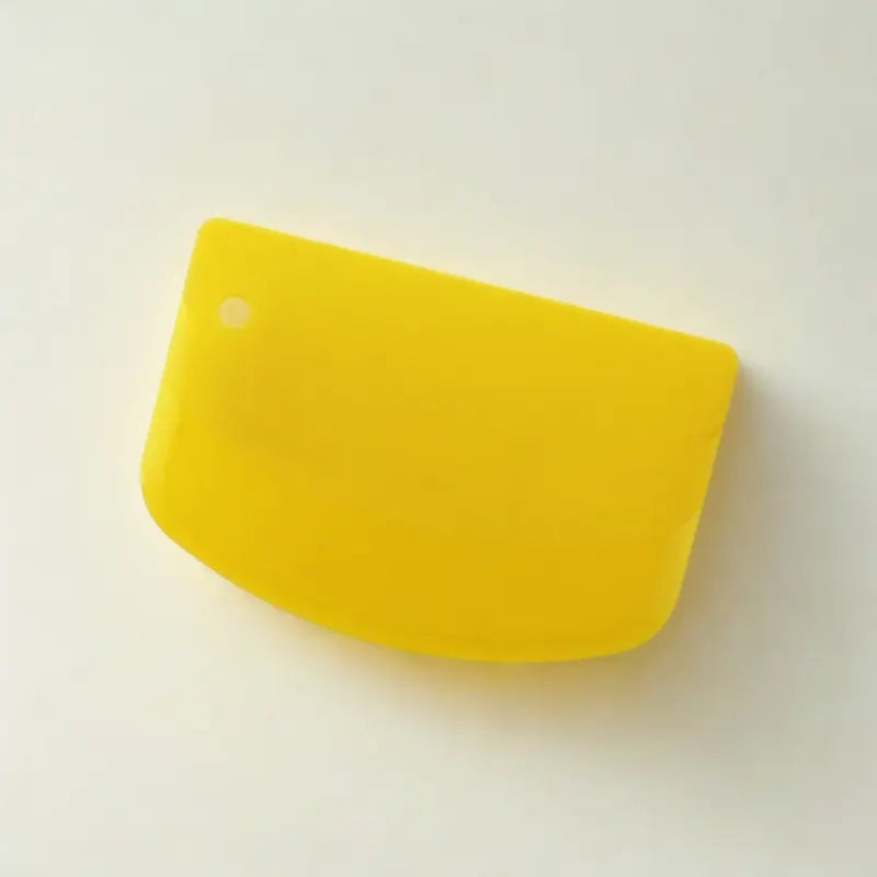 Coupe-pâtes en silicone jaune sur fond blanc