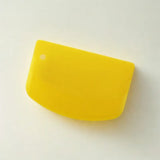 Coupe-pâtes en silicone jaune sur fond blanc