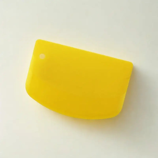 Coupe-pâtes en silicone jaune sur fond blanc