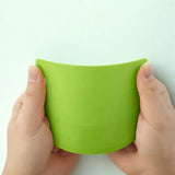 Coupe-pâte en silicone vert tenu par des mains sur fond blanc